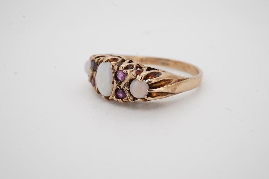 A 9ct, three stone white opal and four stone ruby set half hoop ring, size P, gross weight 4.2 grams. Condition - fair